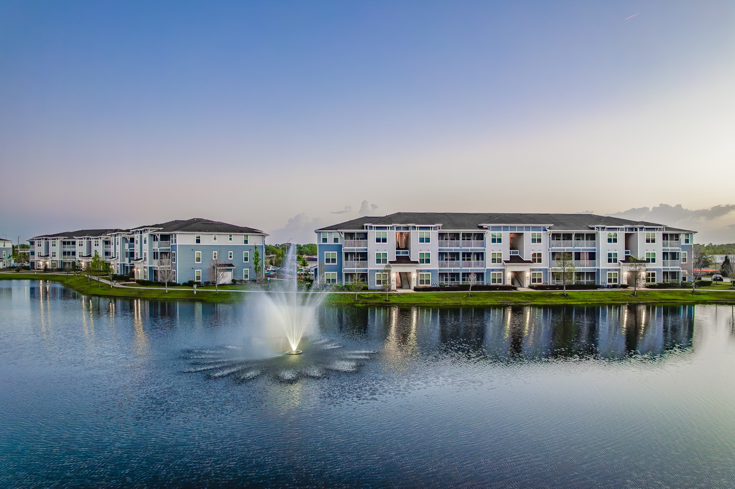 Academy Park apartment buildings by water at dusk